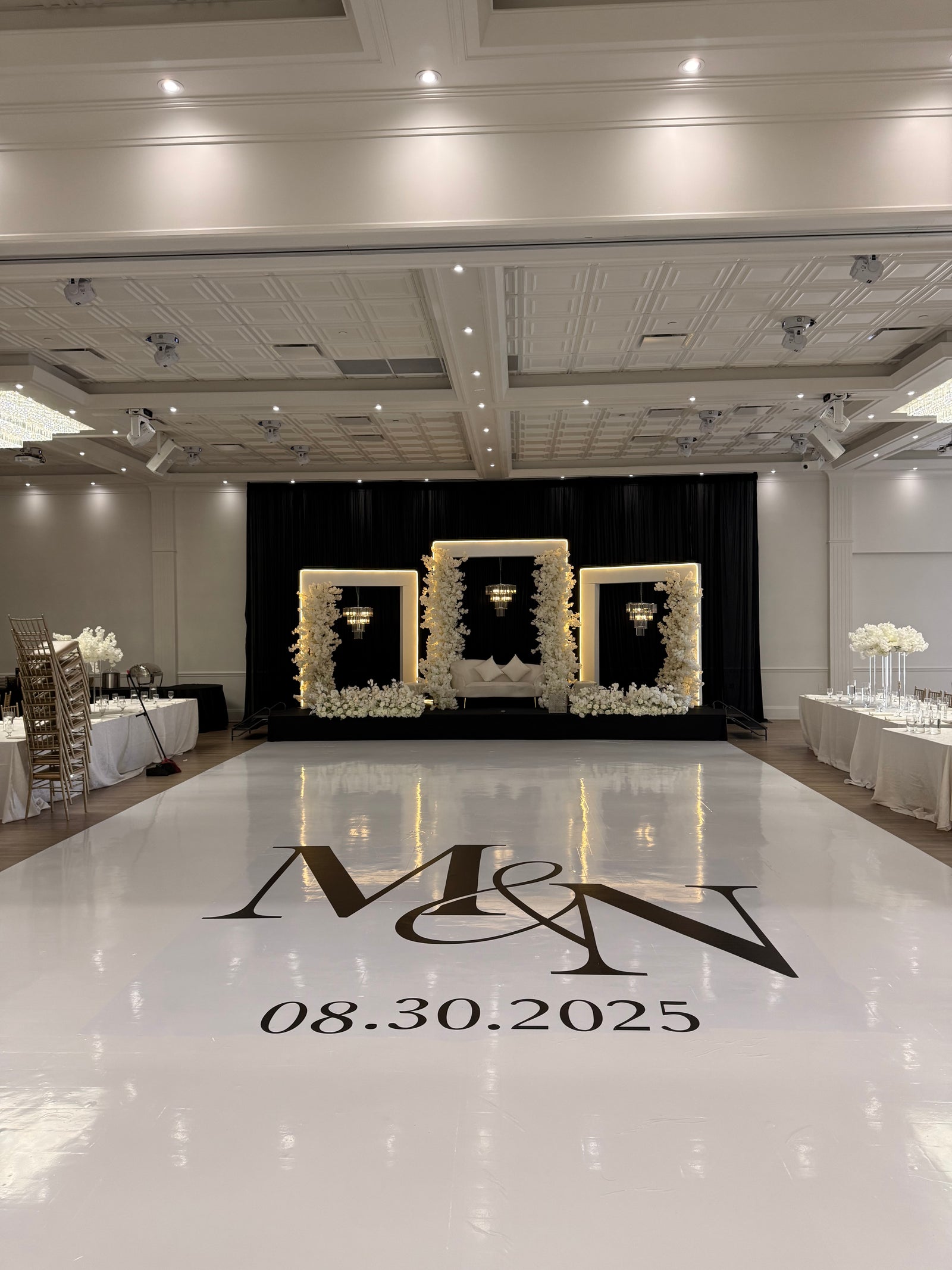 Elegant white custom event floor and floral stage installation